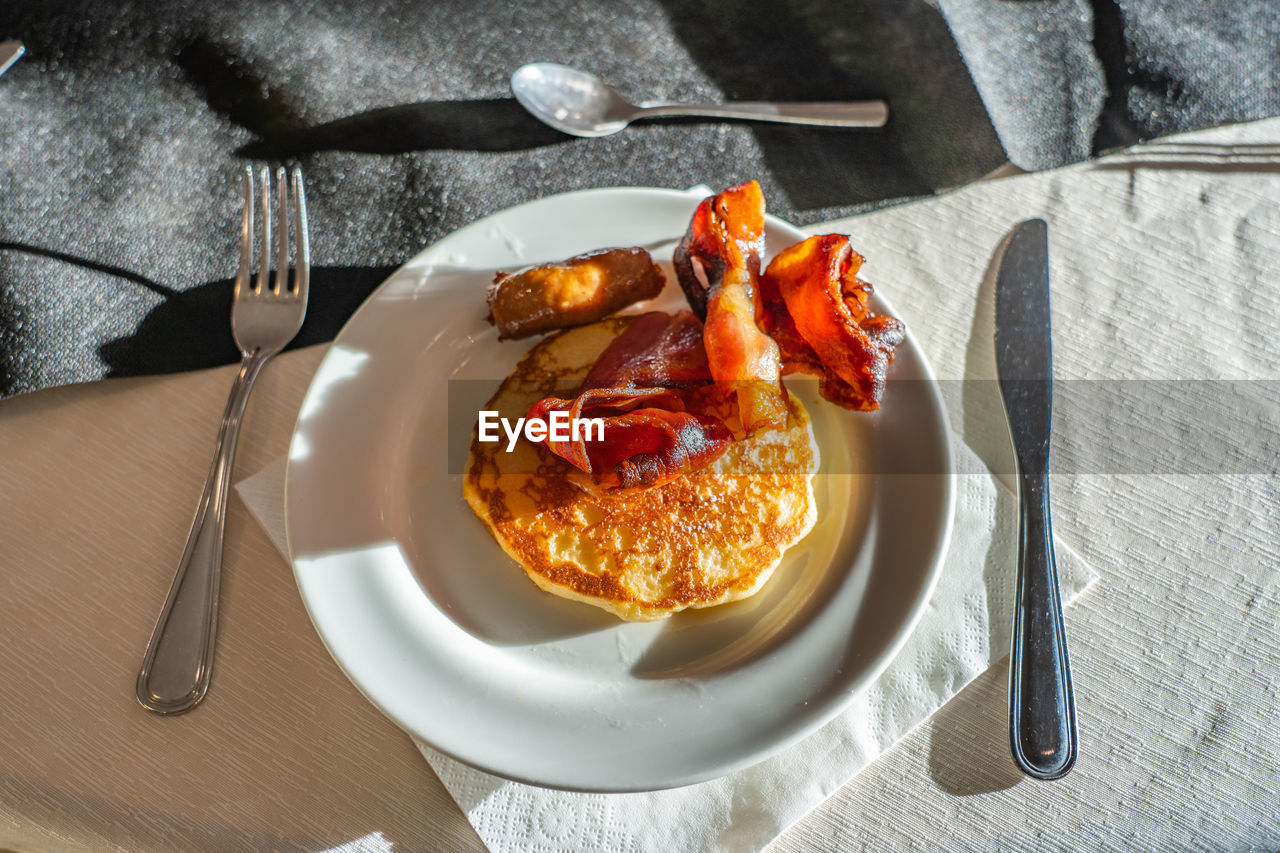 Yummy pancake and grilled cured meat for breakfast meal