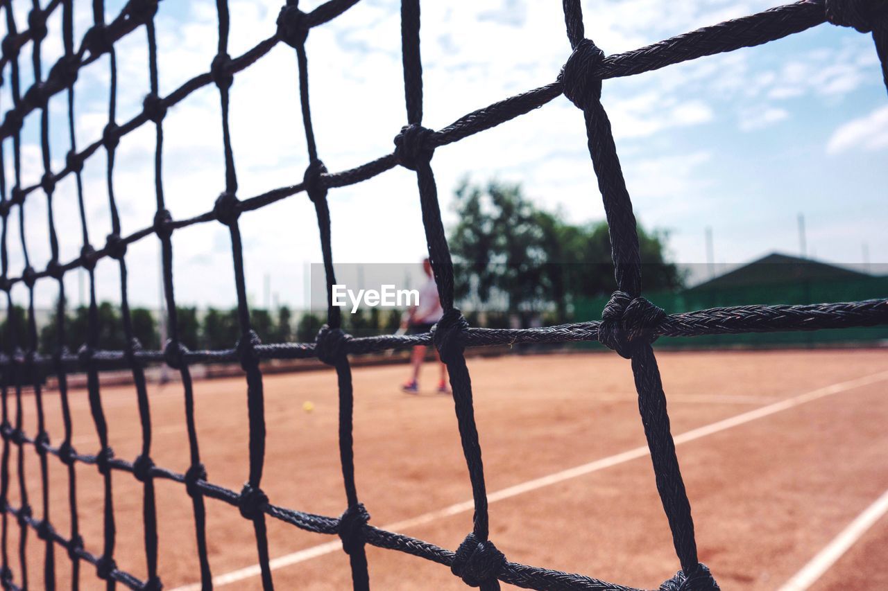 Defocused image of man playing tennis at court