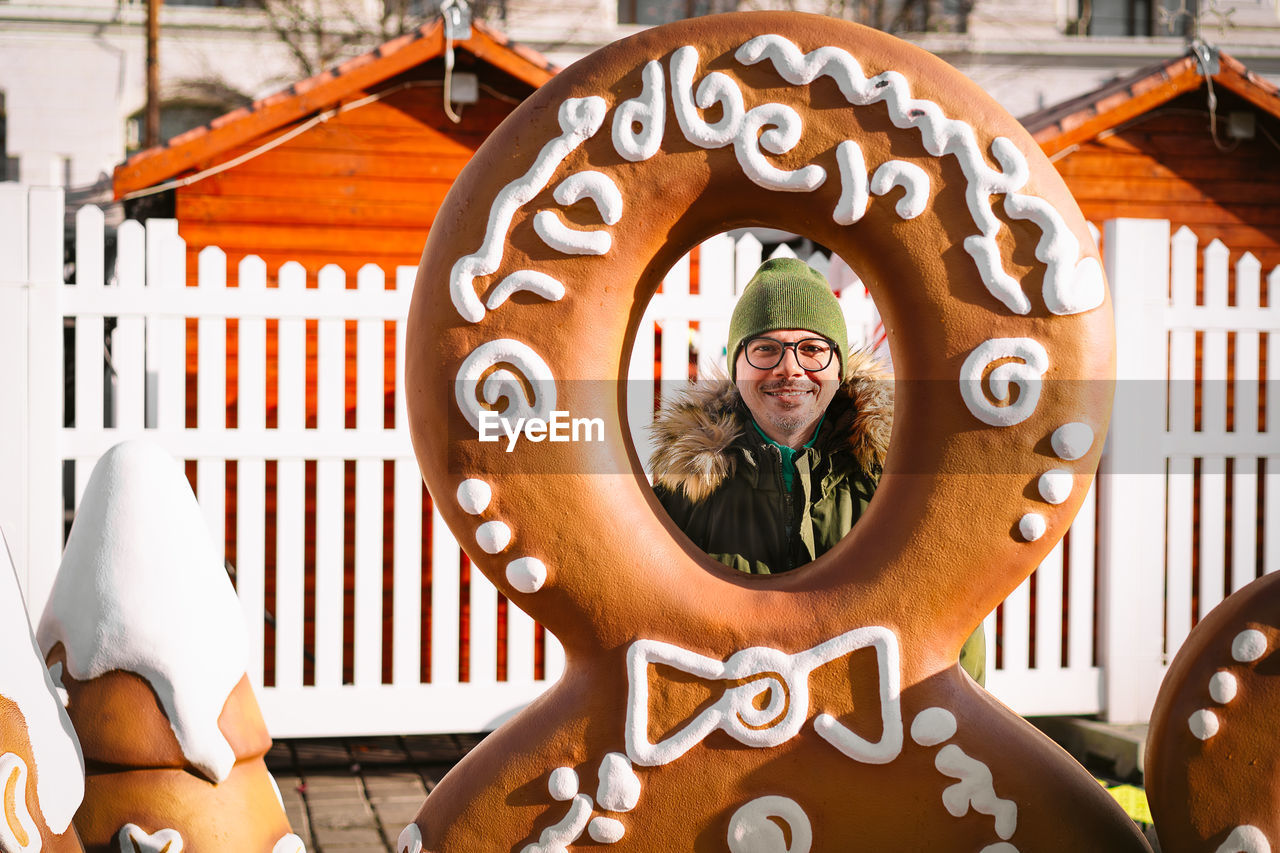 Smiling man at christmas market with gingerbread man frame