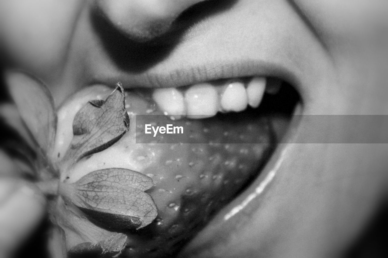 Close-up of young woman eating strawberry
