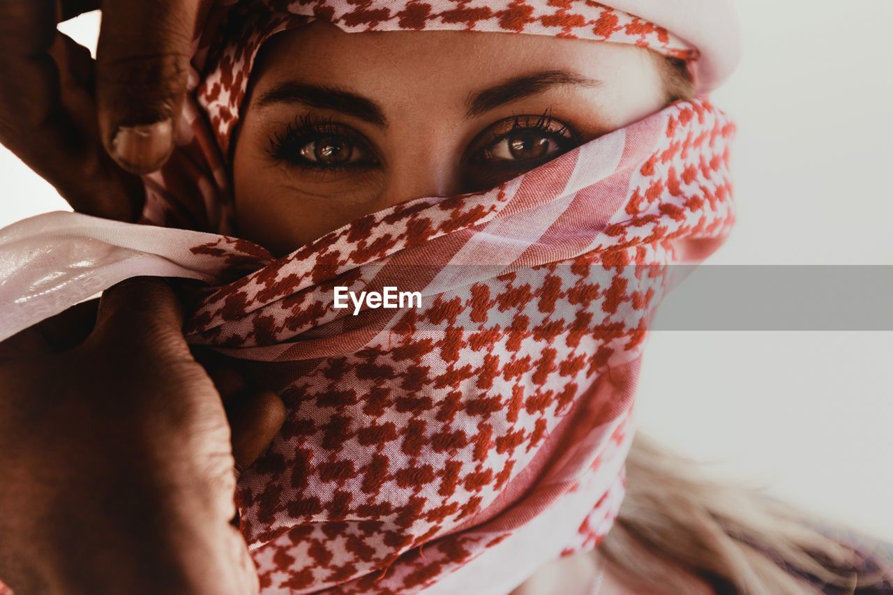 Close-up portrait of young woman covering face with headscarf