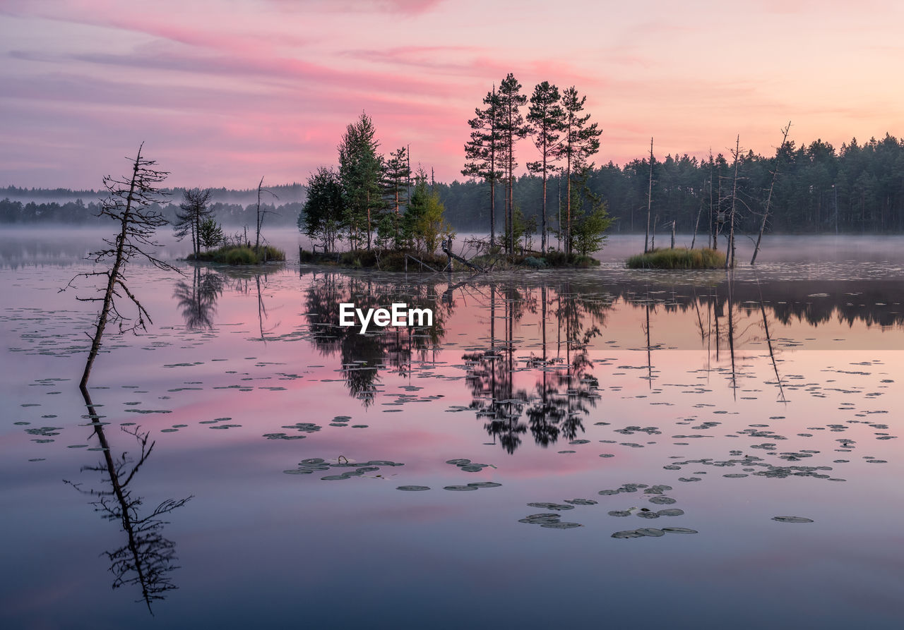 Scenic view of lake against sky at sunset