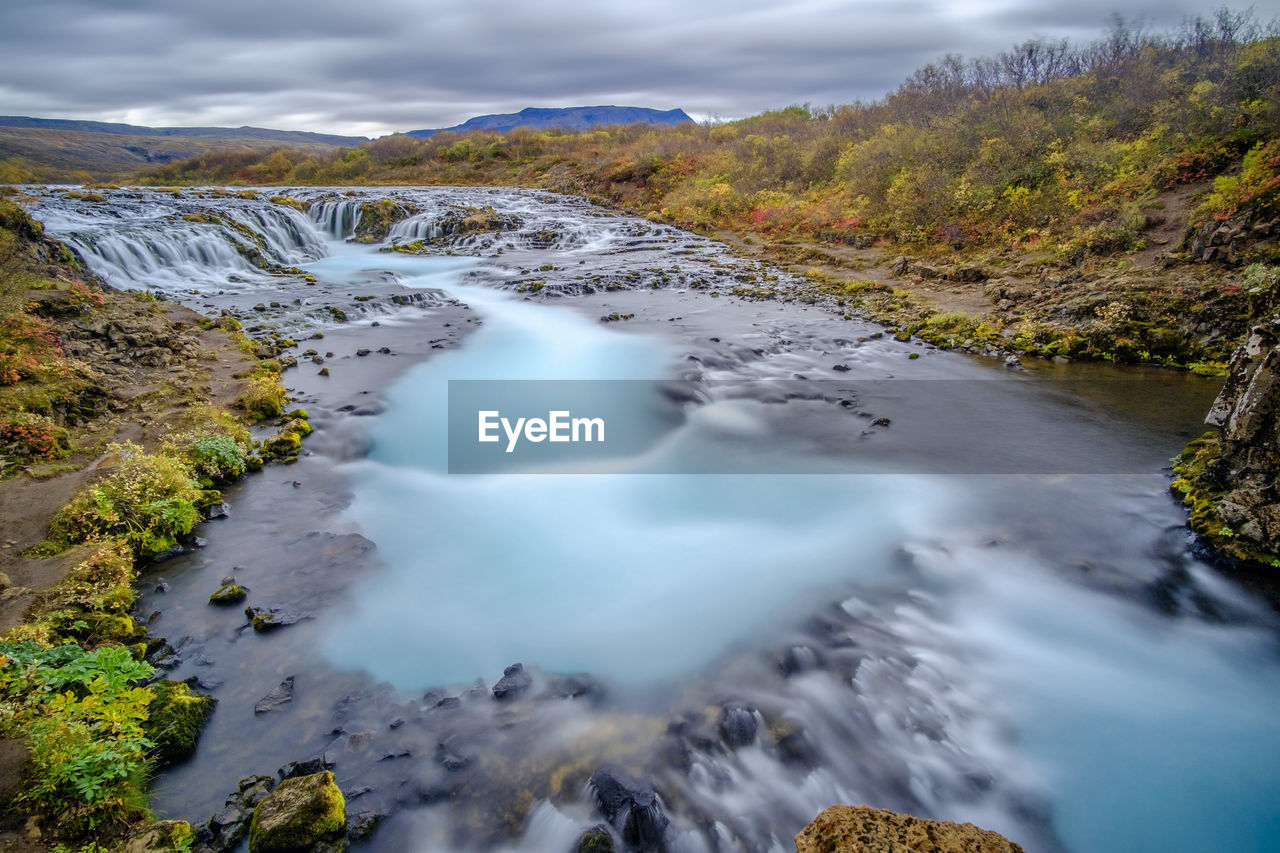 SCENIC VIEW OF STREAM FLOWING THROUGH LAND