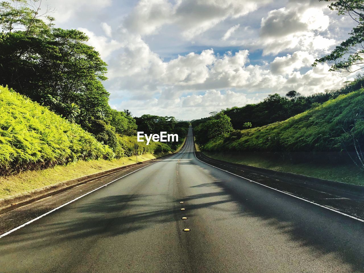 Road amidst trees against sky