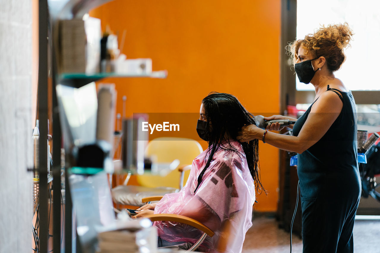 Woman in the hairdresser's with mask, cutting her hair, beauty salon