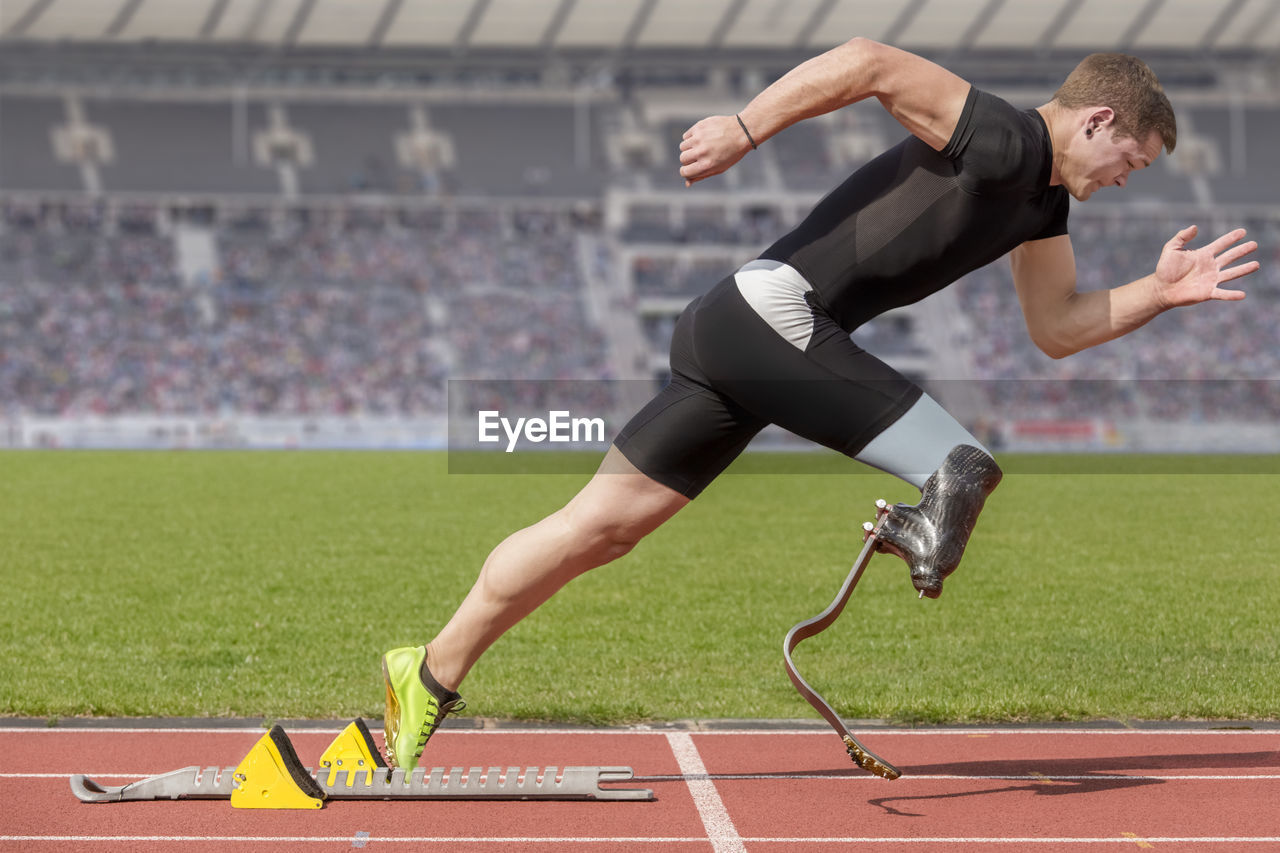 Male athlete with amputated leg on running on track