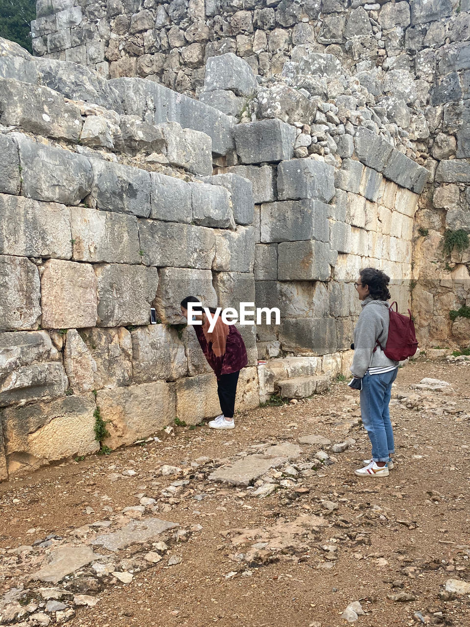 FULL LENGTH REAR VIEW OF MEN WALKING ON WALL