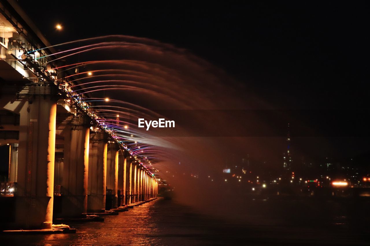 ILLUMINATED LIGHT TRAILS IN CITY AT NIGHT DURING SUNSET