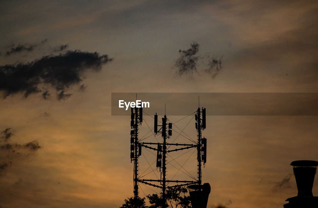 LOW ANGLE VIEW OF COMMUNICATIONS TOWER AGAINST SKY DURING SUNSET