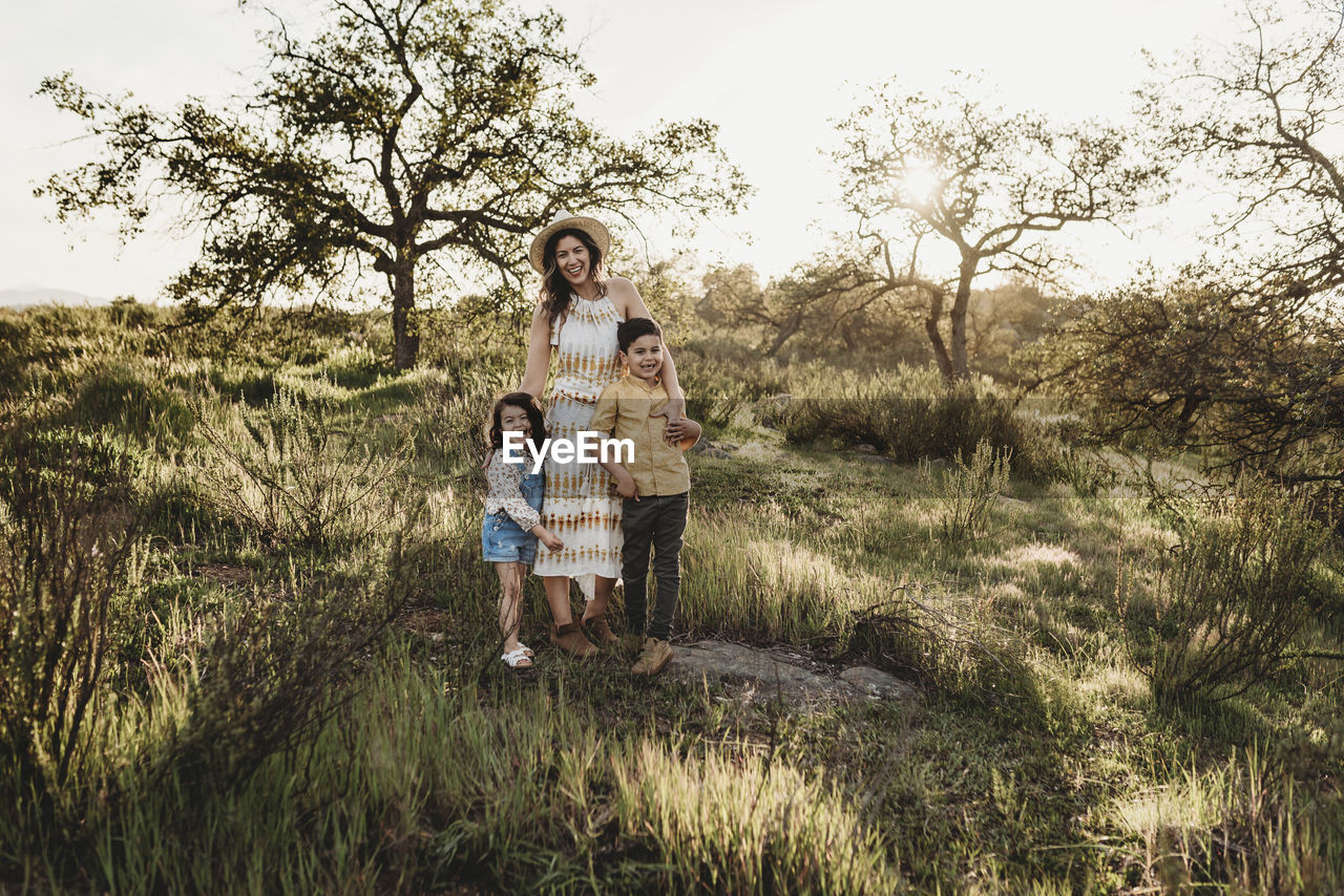 Portrait of beautiful mother and young children in sunny field