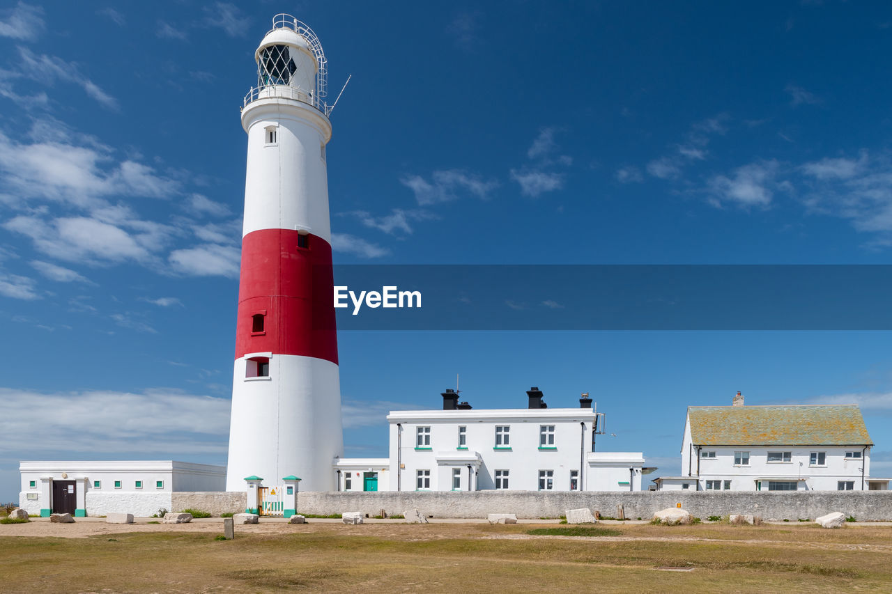 LIGHTHOUSE AGAINST BUILDINGS AND SKY