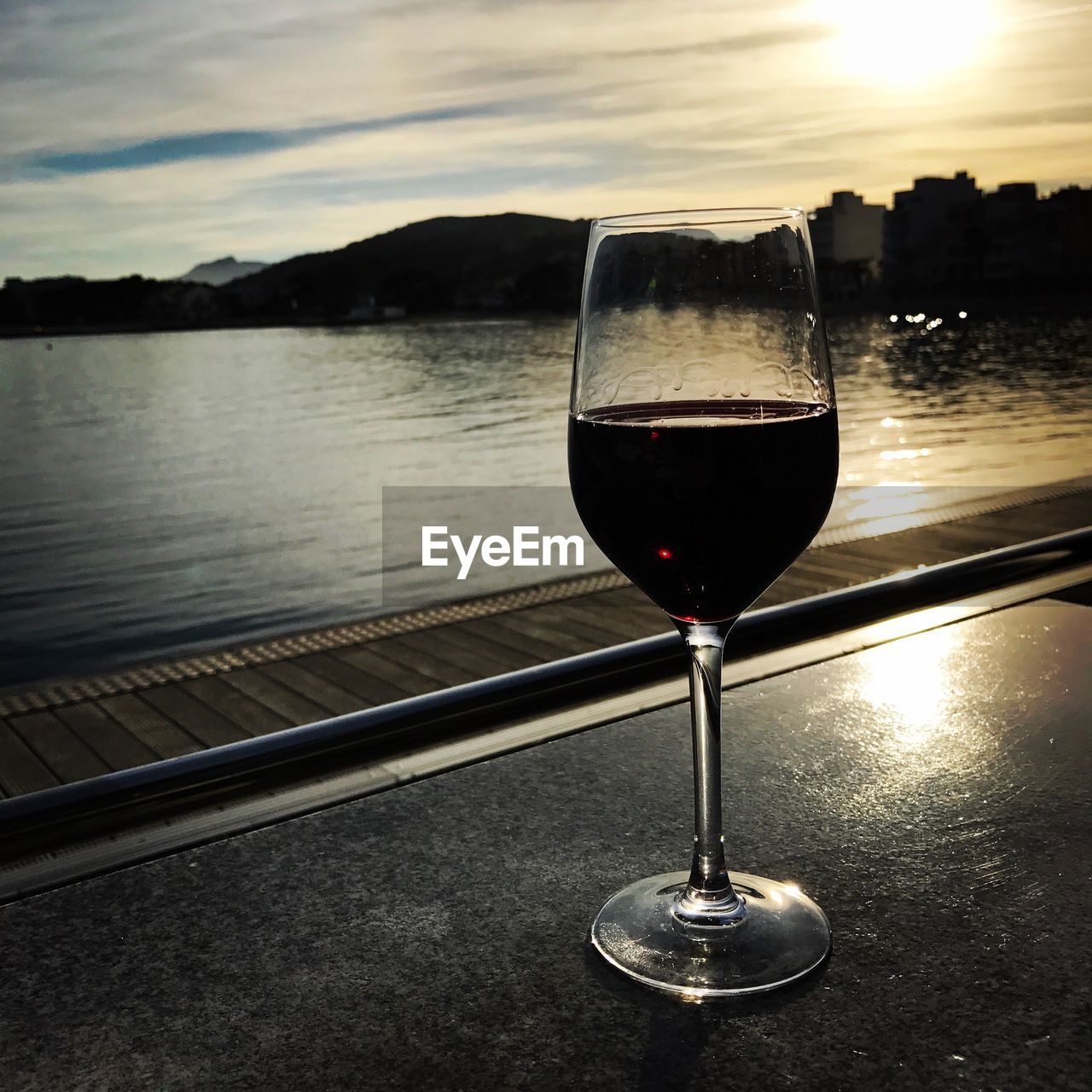 CLOSE-UP OF WINEGLASS AGAINST RIVER