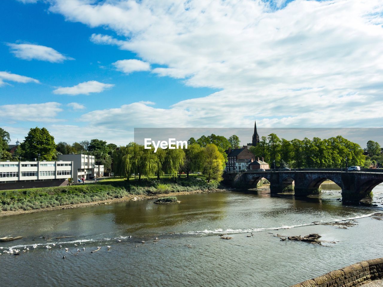 Bridge over river in city against sky