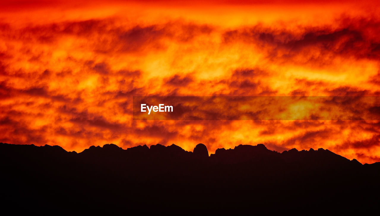 SCENIC VIEW OF SILHOUETTE MOUNTAIN AGAINST DRAMATIC SKY