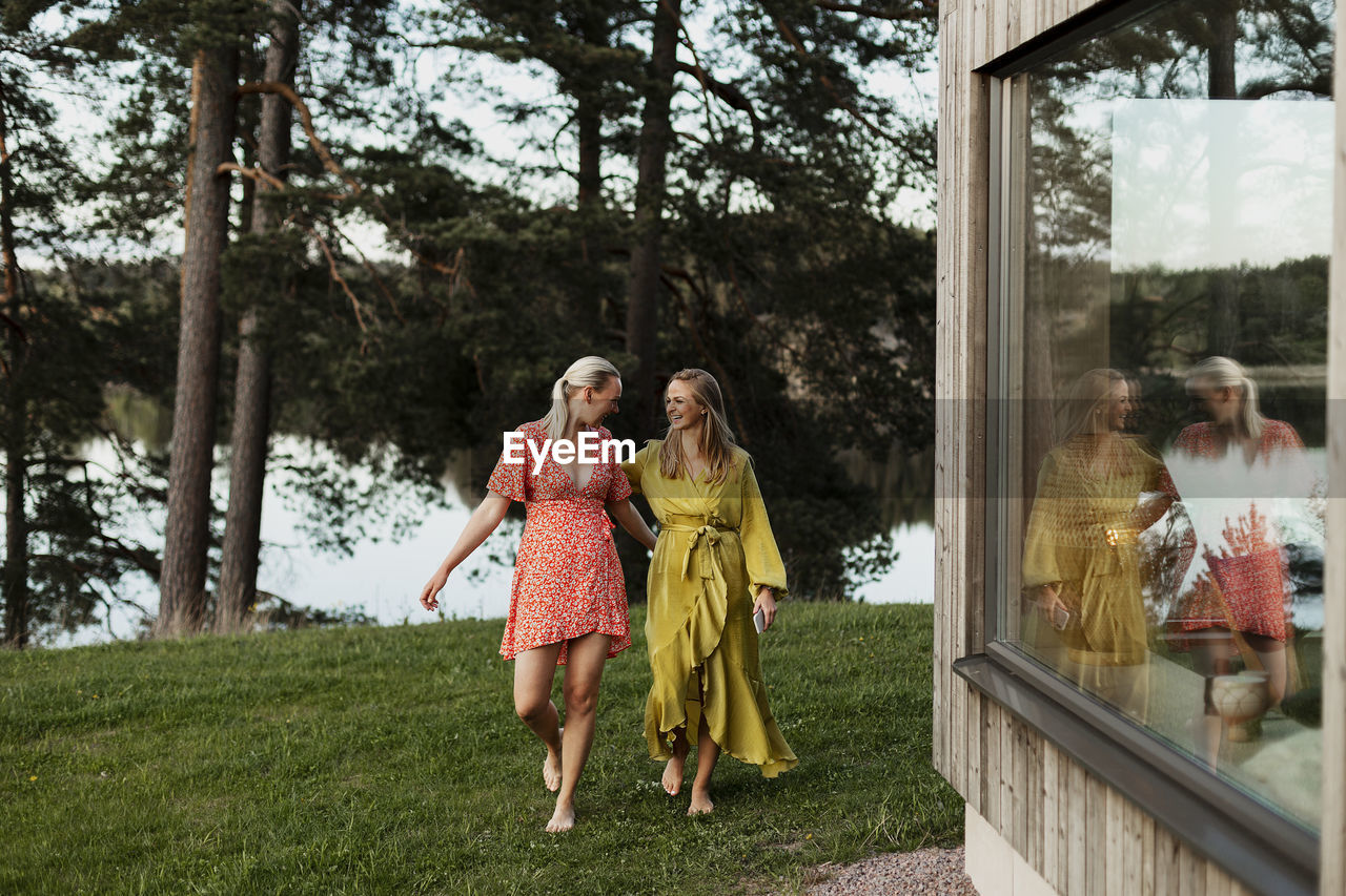 Smiling female friends walking in backyard