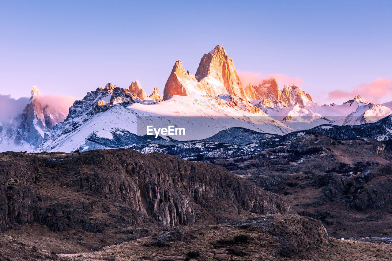 Scenic view of snowcapped mountains against sky during sunset