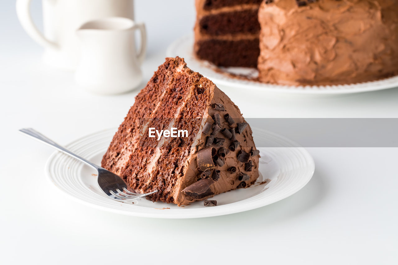 A large slice of triple layered decadent chocolate cake, ready for eating.