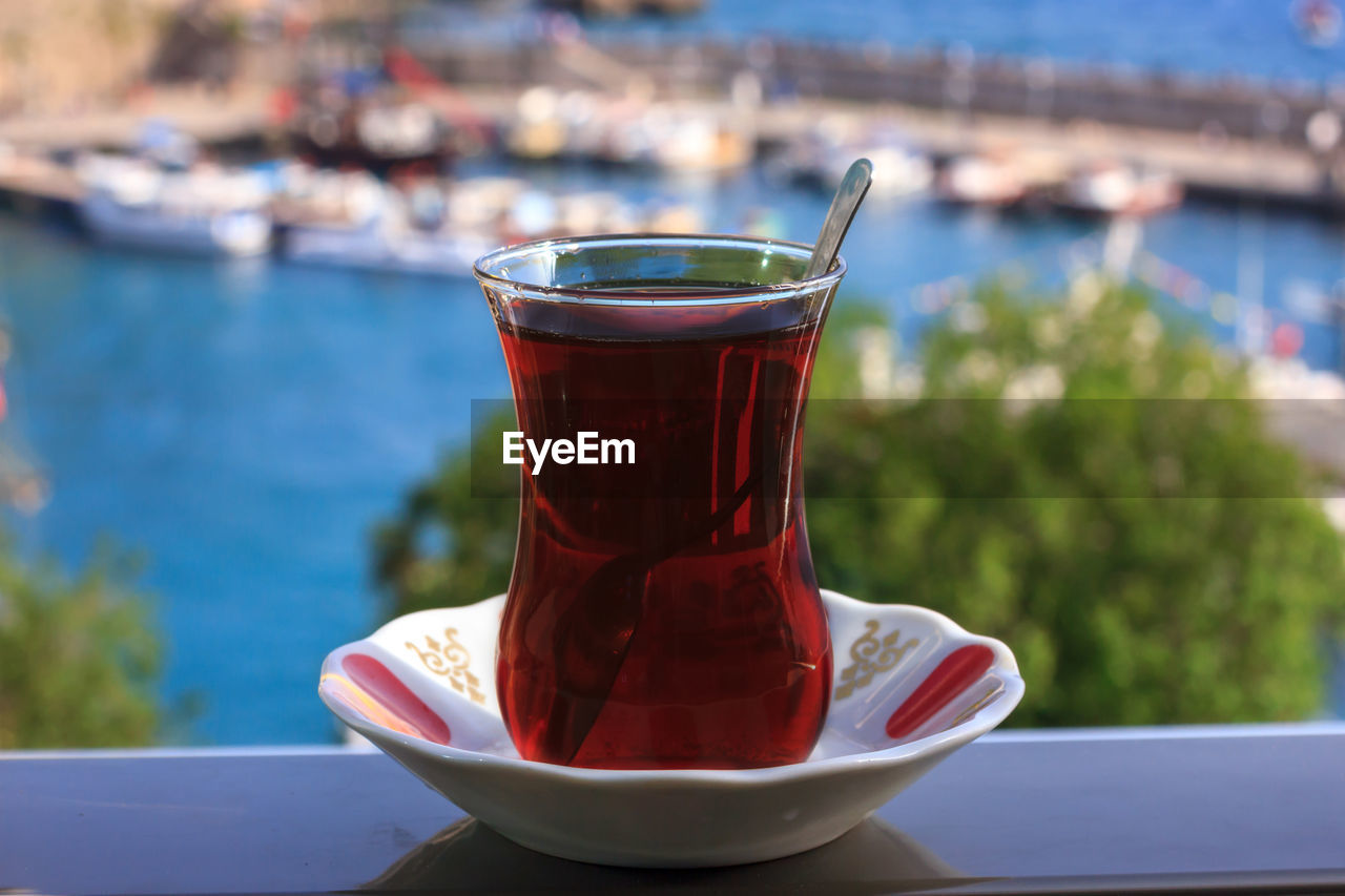 Turkish black tea in traditional glass on background of blue mediterranean sea