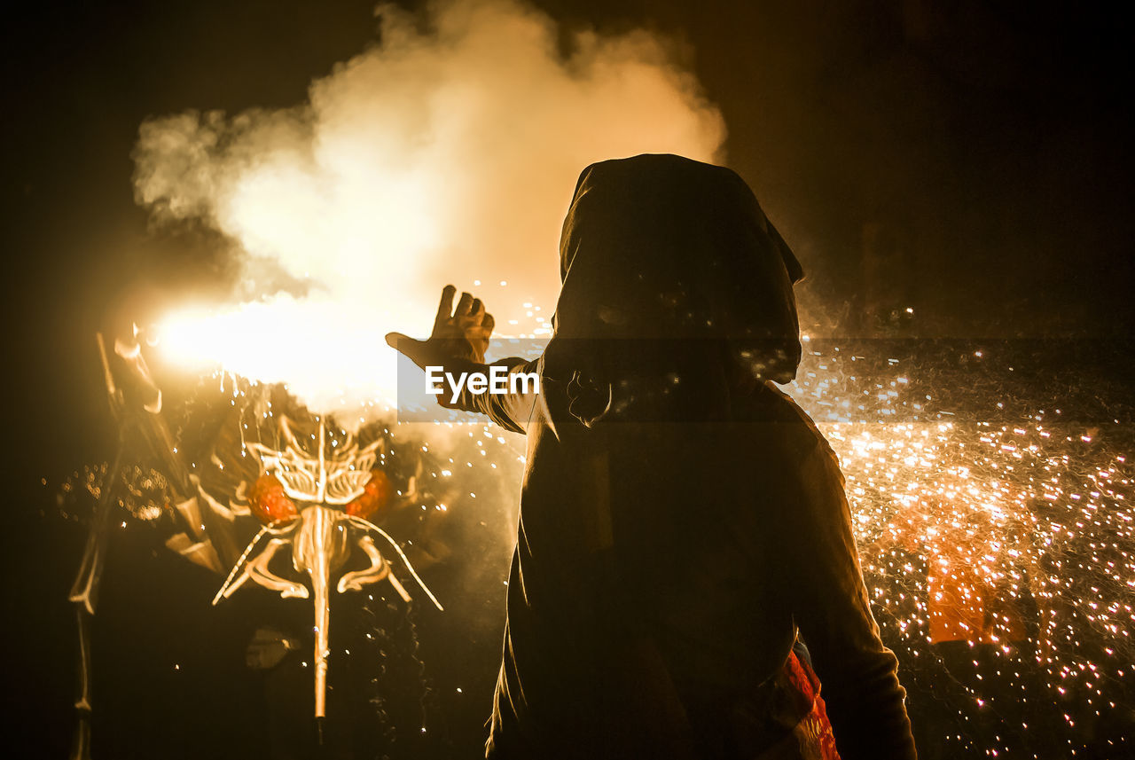 Person standing by fire at traditional event 