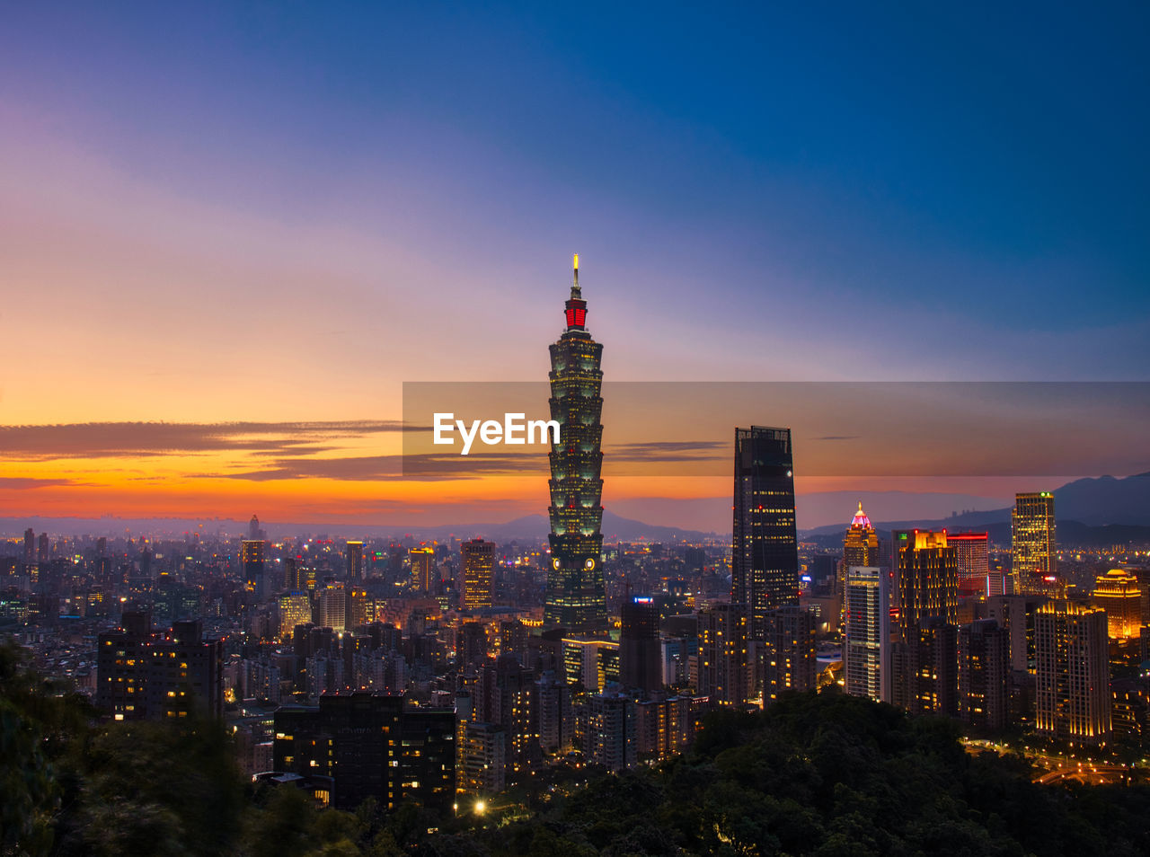 Illuminated buildings in city during sunset