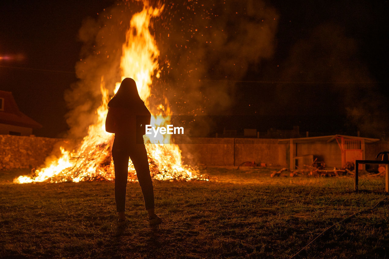 Rear view of young woman looking at bonfire