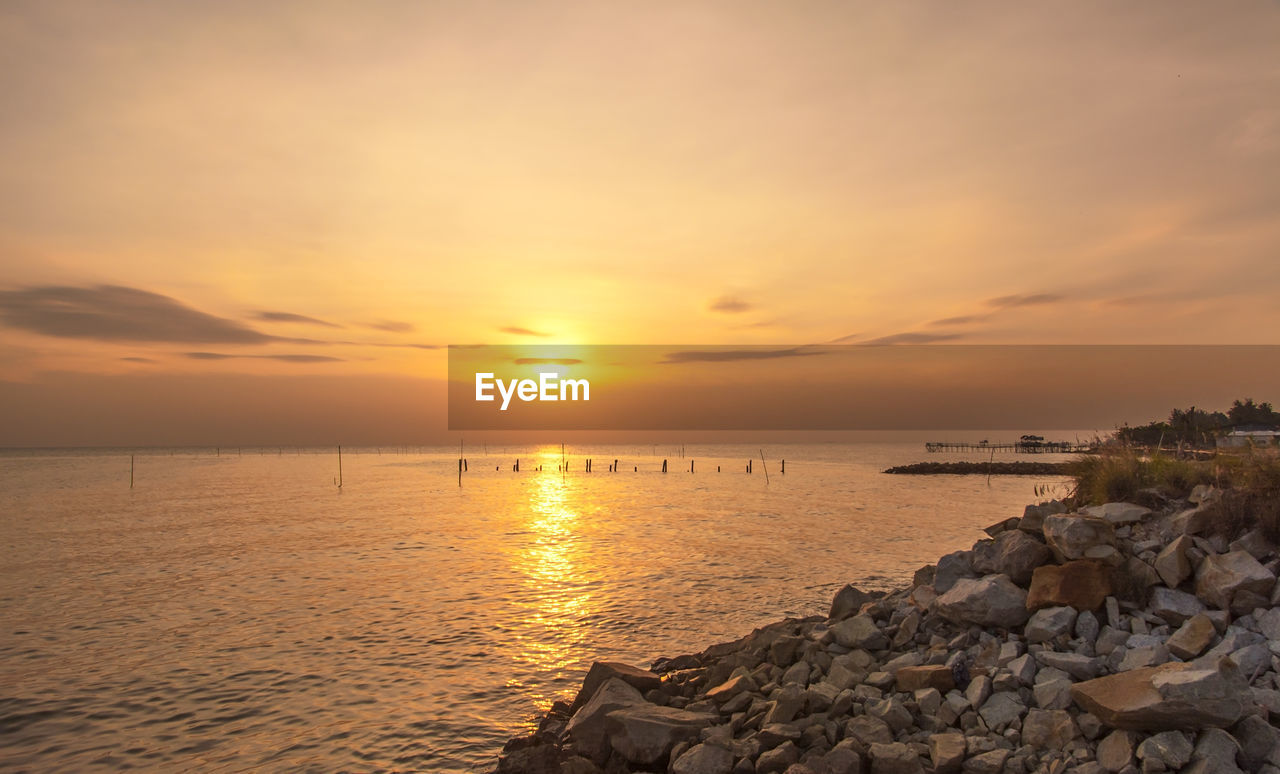 Scenic view of sea against sunset sky