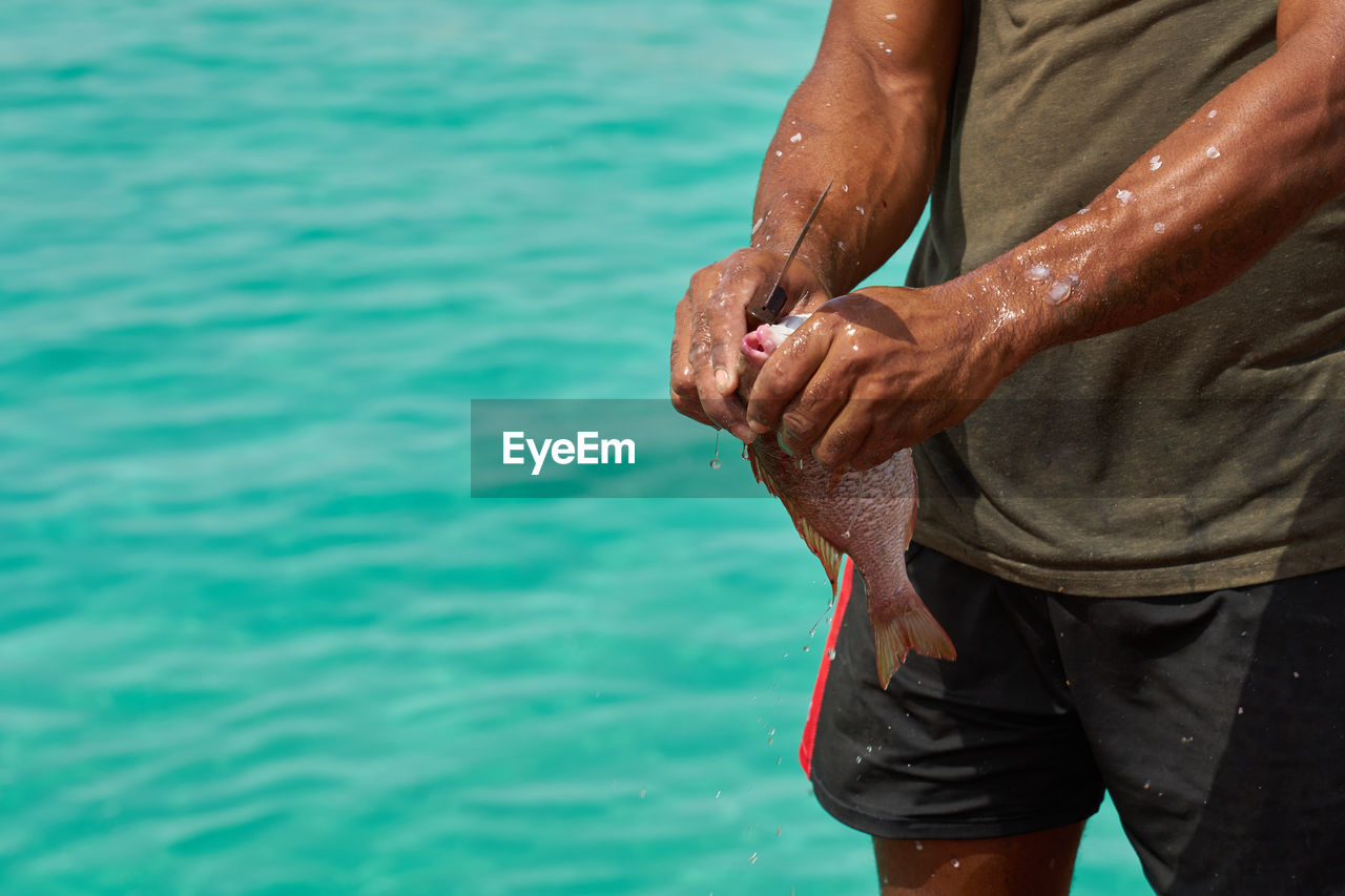 low section of man holding fish