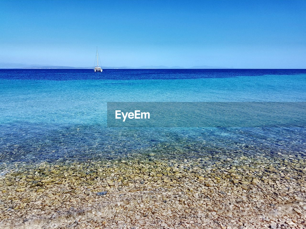 SAILBOAT IN SEA AGAINST CLEAR BLUE SKY