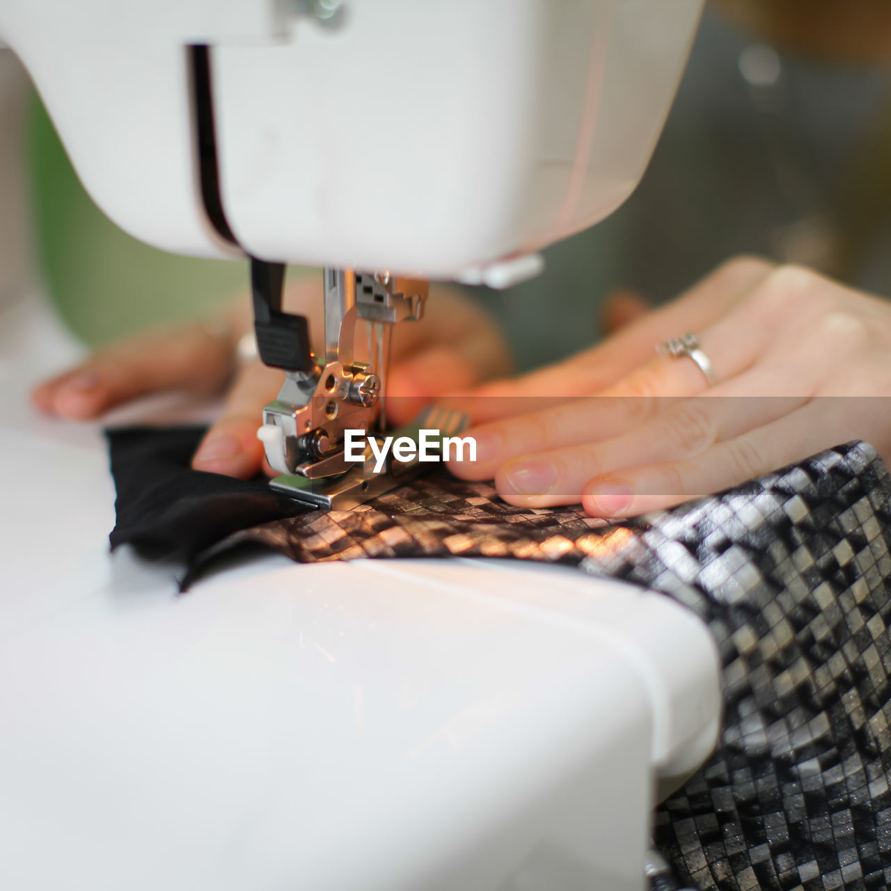 Cropped hands of woman sewing clothes on machine