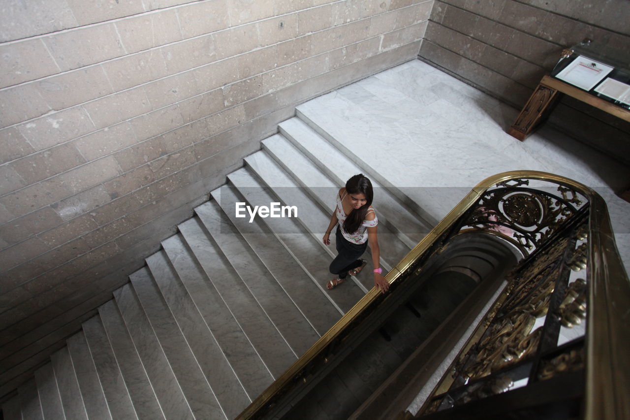 High angle view of young woman walking on steps 