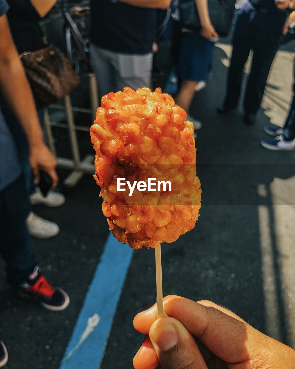 MAN HOLDING ICE CREAM ON STREET IN CITY