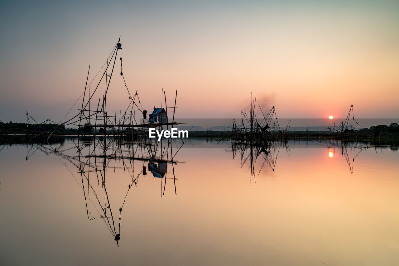 SAILBOATS ON LAKE AGAINST SKY DURING SUNSET