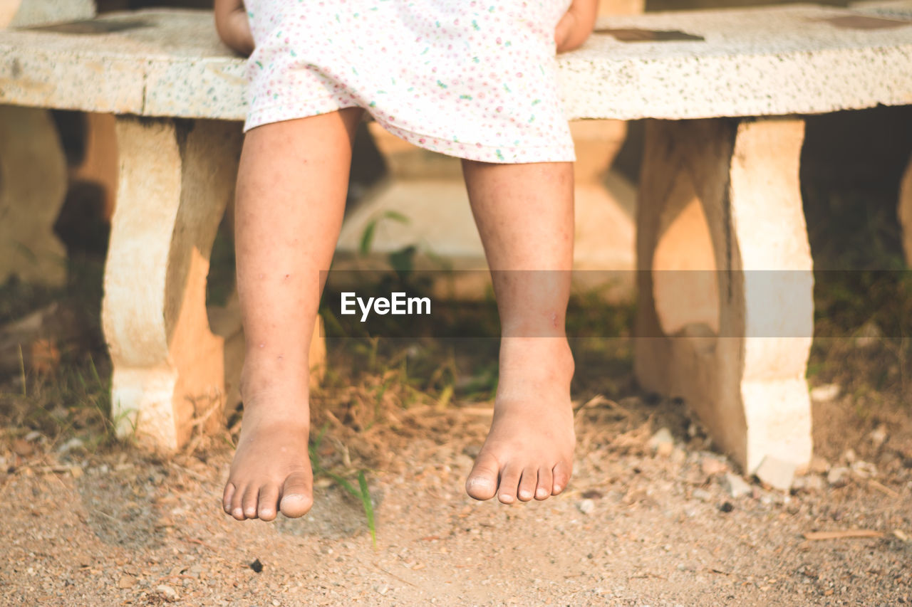 Low section of girl sitting on bench