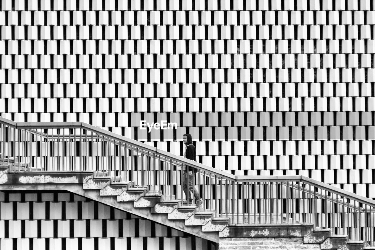 Low angle view of man moving on steps against building