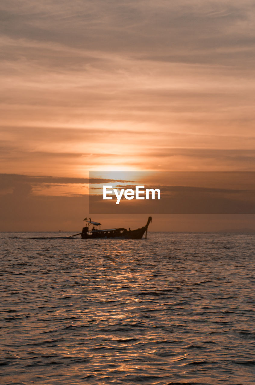 Fisherman boat going out at sunset in thailand