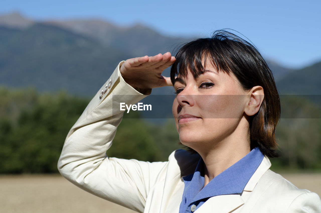 Portrait of woman shielding eyes