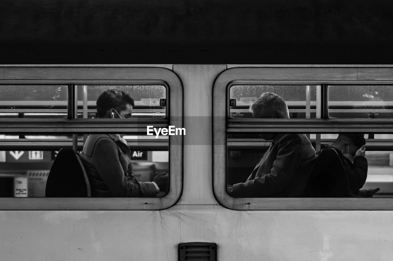 Side view of two men on train