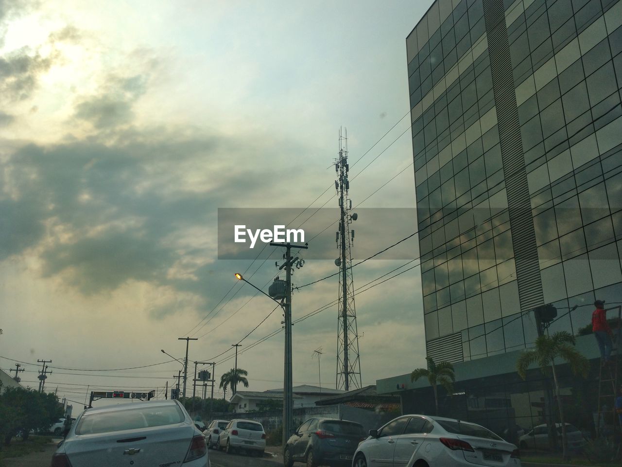 CARS ON ROAD AGAINST SKY IN CITY