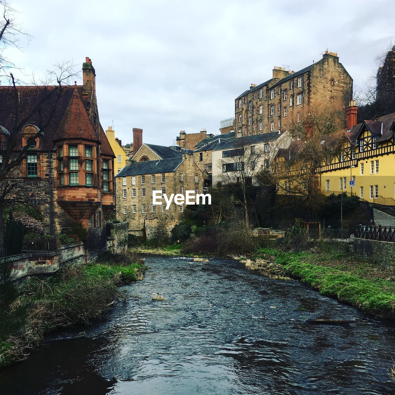 BUILDINGS BY RIVER AGAINST SKY IN CITY