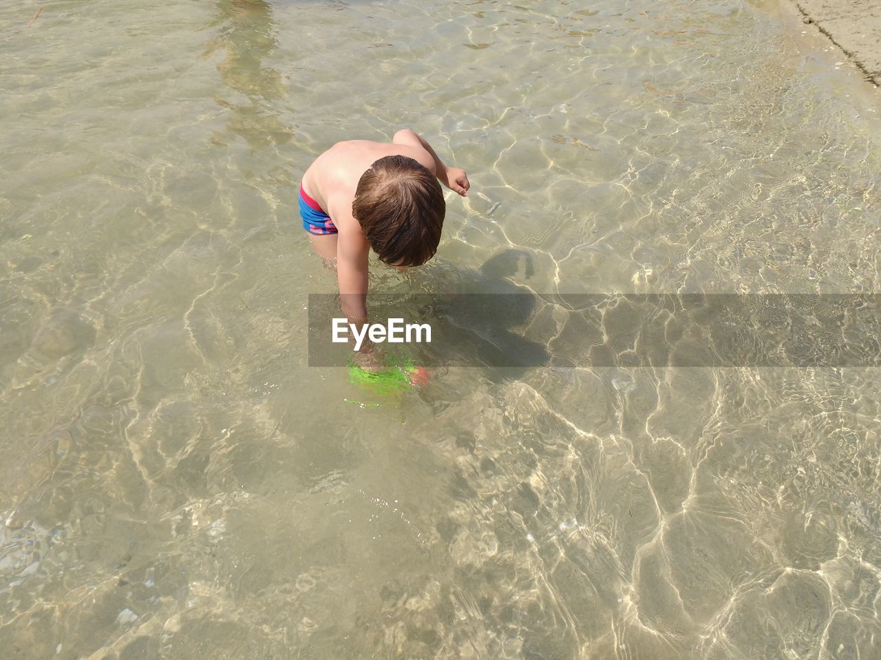 HIGH ANGLE VIEW OF BOY SWIMMING IN WATER