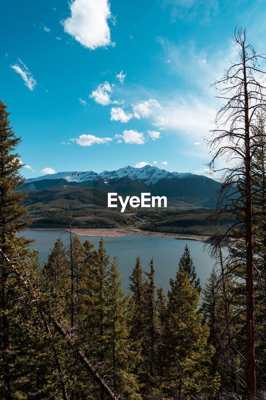 Scenic view of lake by mountains against sky