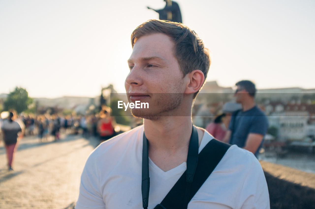 Young man looking away at charles bridge against sky