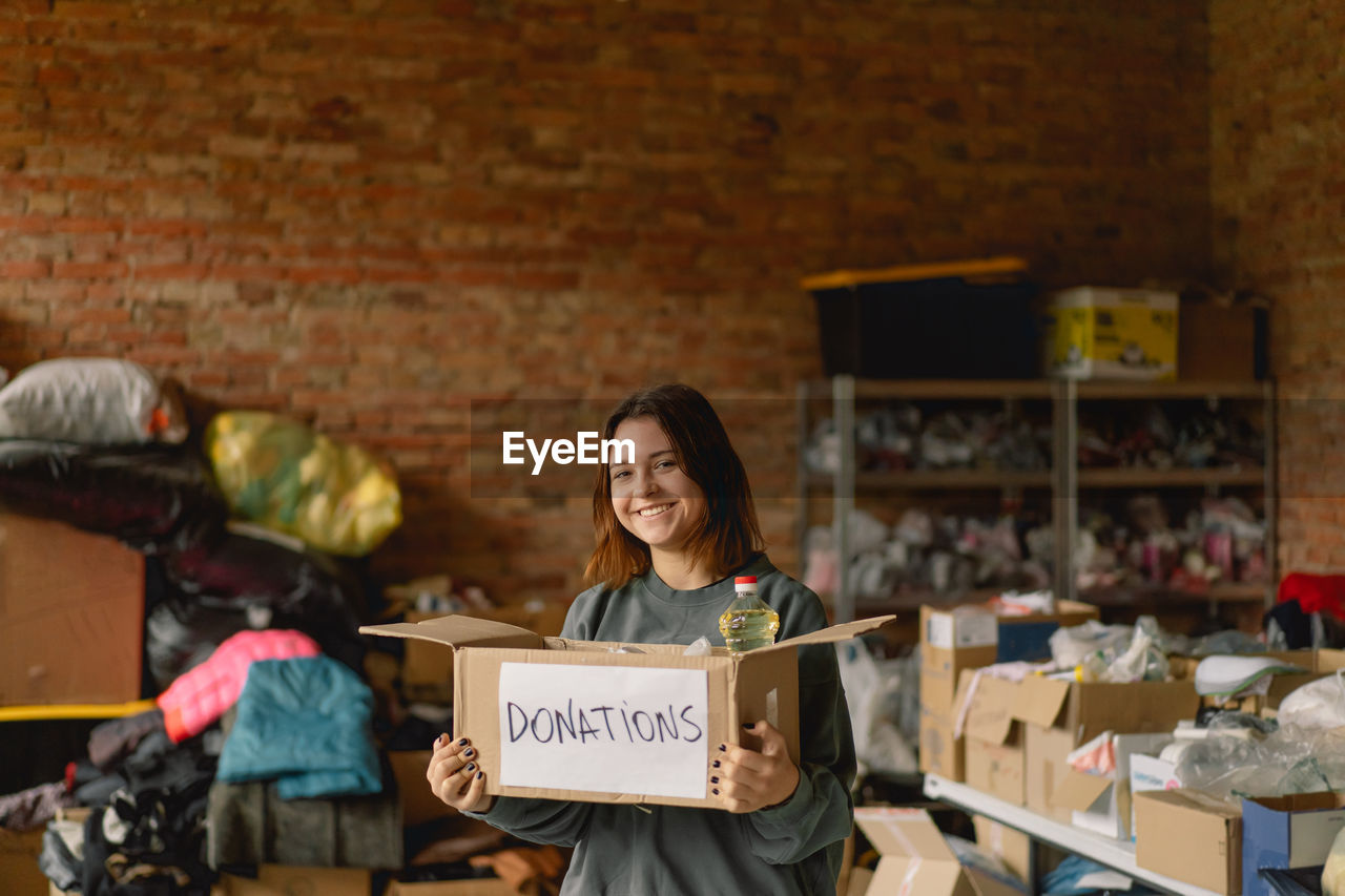 Volunteer teengirl preparing donation boxes for people.