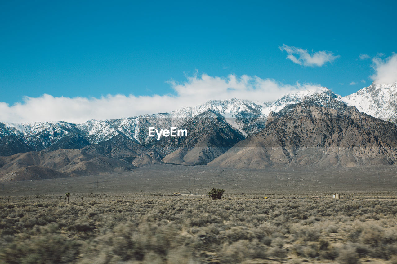 Scenic view of mountains against blue sky