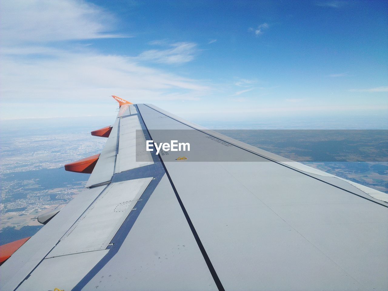 AERIAL VIEW OF AIRPLANE WING AGAINST SKY