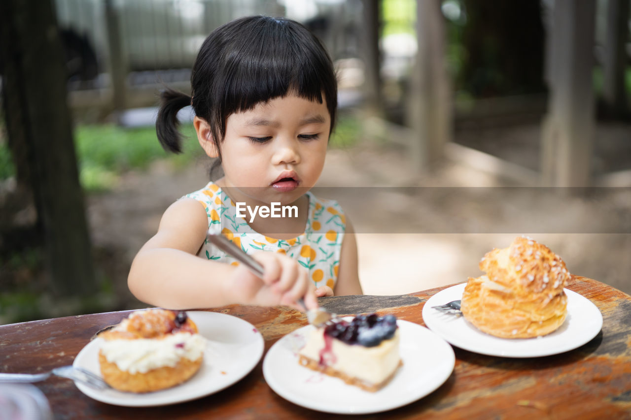 Full length of cute baby girl in plate on table