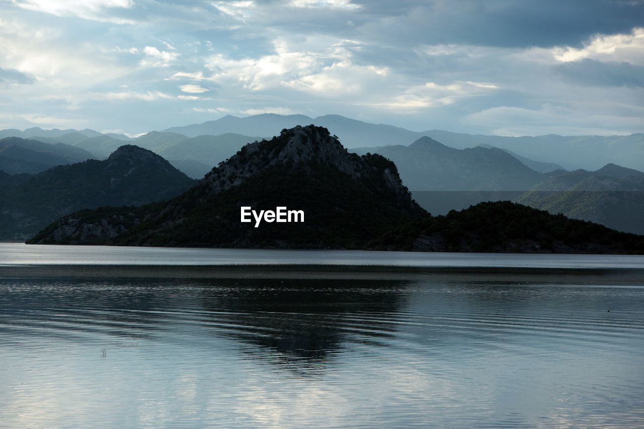 Scenic view of lake against cloudy sky