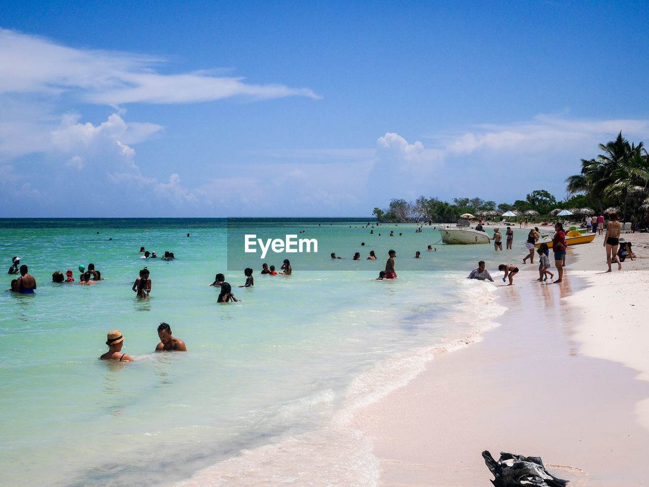 Crowd enjoying at beach against sky