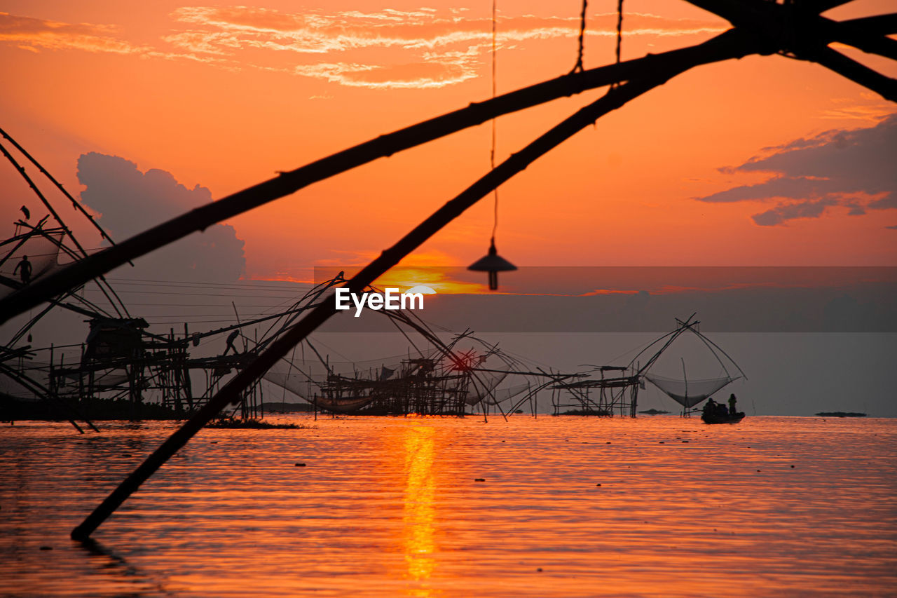 Silhouette ship in sea against sky during sunset