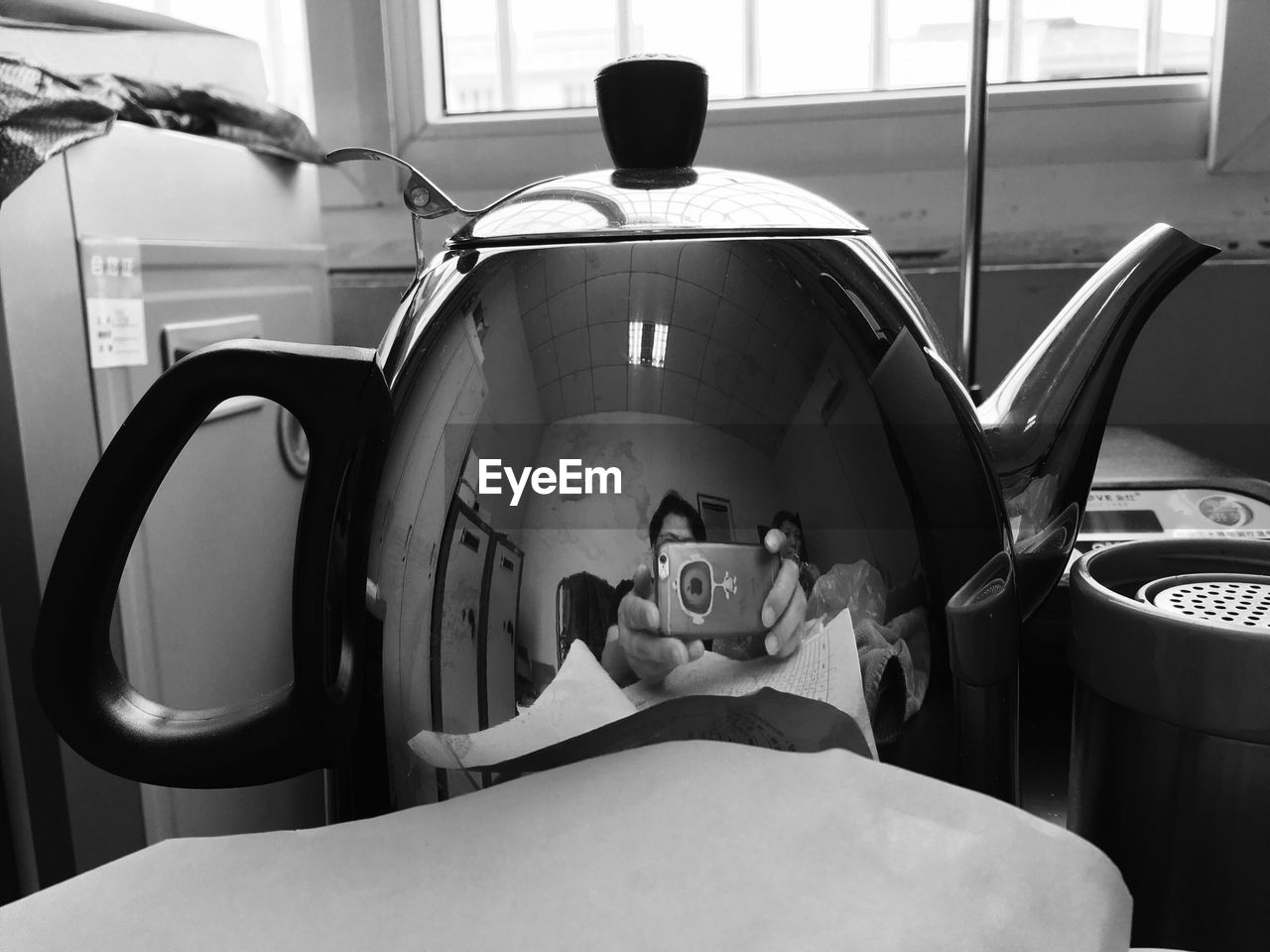 REAR VIEW OF BOY USING SMART PHONE IN KITCHEN